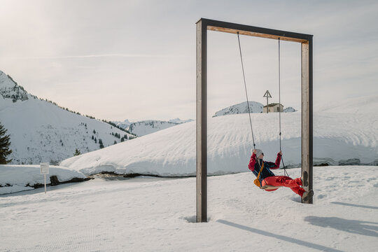 Schaukelnde Frau im Winterlichen Sonnenschein bei Dam&uuml;ls im Gro&szlig;en Walsertal