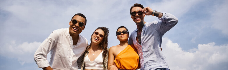 happy diverse attractive friends with trendy sunglasses posing actively on rooftop together, banner