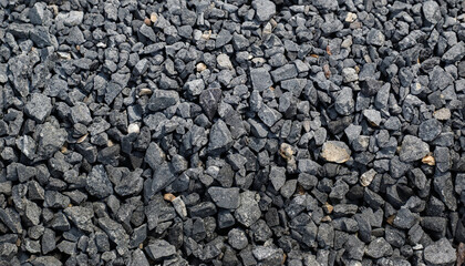 Black road stones gravel texture, rocks for construction, dark background of crushed granite gravel, small rocks, closeup