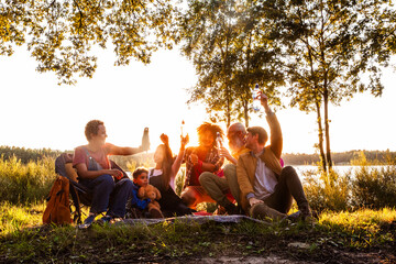 This image radiates the joy of a mixed group of individuals enjoying a picnic at lakeside during...