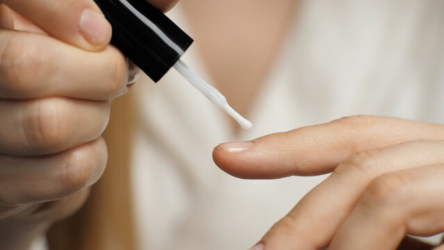 Close-up of applying nail polish on a nail. Nail brush. Manicure. Beauty care