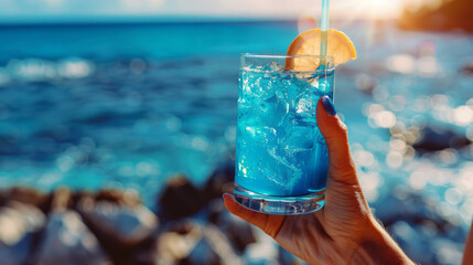 Beachside with hands holding a vivid blue cocktail