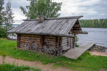 Cabaña de madera cerca del río y bicicletas en el pueblo de Mandrogi, en un día nublado