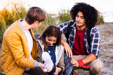 In this image, a moment of care unfolds in the tranquility of nature as a group of friends attend...