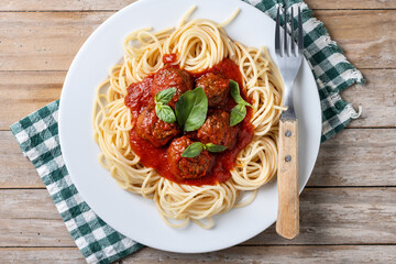 Spaghetti with meatballs on wooden table