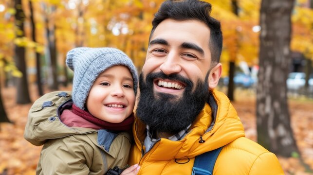 A man and a child are smiling and posing for a picture in a park