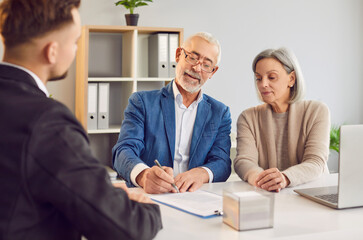 Obraz premium Senior couple purchasing property with realtor signing contract of new house. After consultation senior couple signing contract real estate property with real estate agent broker sign contract