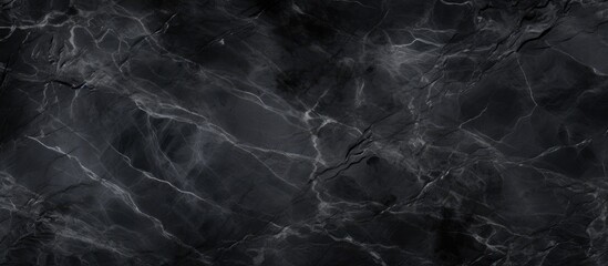 A dark, black marble background with visible texture throughout. The surface showcases intricate patterns and veining characteristic of marble. - obrazy, fototapety, plakaty