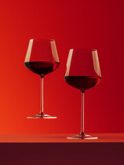 Elegant Float of Red Wine Glasses in Mid-Air with Red Monochromatic Backdrop