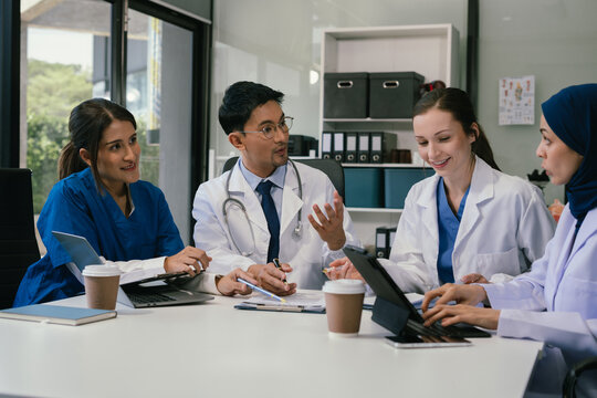 Medical, meeting and laptop for team in office in discussion, brainstorming and planning. Doctor, nurse and computer on desk, teamwork or workshop for data analytics. - Powered by Adobe