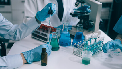 Fototapeta premium Science and medicine, scientist analyzing and dropping a sample into a glassware, experiments containing chemical liquid in laboratory on glassware, innovative and technology.