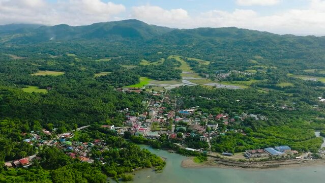 Drone view of Looc Poblacion with residential area at coast and pier. Tablas Island. Romblon, Philippines.