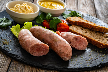 Easter breakfast - boiled white sausages, toasts and horseradish on wooden table

