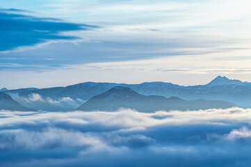 Fototapeta na wymiar うごめくような雲と山のシルエットのドラマチックな遠景。