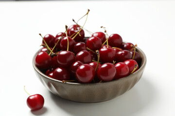 Ripe cherry fruits in a bowl on a white background