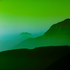 Spectacular mountain ranges silhouettes in shades of green.