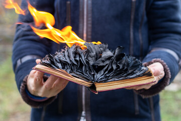 an open burning book in the hands of a woman close-up