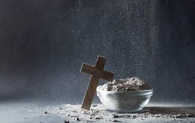 Ashes falling on Christian cross and container isolated gray background