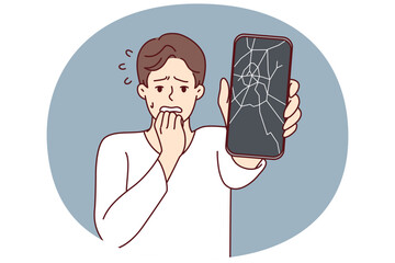 Man reacts emotionally to broken phone by bringing hand to mouth and experiencing shock due to breakdown. Guy with broken smartphone needs to replace display matrix by service center employees