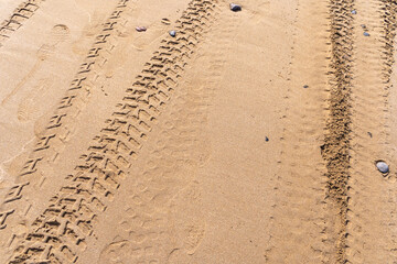 Wheel Tracks on Beach Texture Background, Sand and Rocky Pattern, Red Morocco Beach © artemstepanov