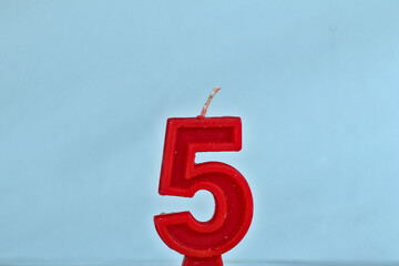 close up on red number fifth birthday candle on a white background.
