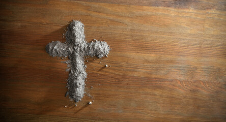 Christian cross made with blessed ashes on wooden table