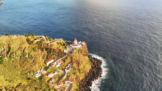 Aerial view of amazing Lighthouse Farol Ponta do Arnel in atlantic ocean, 4k footage. Sao Miguel, Azores, Portugal.