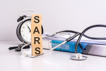 text SARS is written on wooden cubes near a stethoscope on a paper background. medical concept....