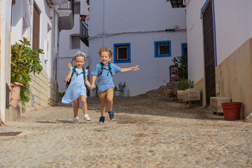Excited travelers run in the old streets of Peniscola, Spain - 755573981