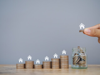 Miniature house icons and stack of coins. The concept of saving money for house, manage time to...