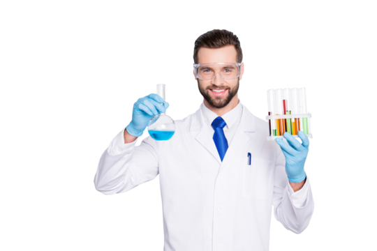 Portrait of cheerful handsome scientist with bristle in white lab coat, tie, protective glasses having test tubes and flask with multi-colored liquid, looking at camera over grey background
