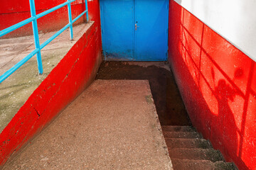 Blue metallic door as entrance to a building basement