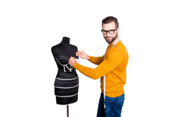 Portrait of attractive nice dressmaker in sweater and jeans with centimeter on neck taking measurements from dress on mannequin with needles looking at camera isolated on grey background