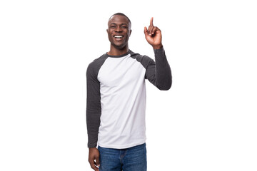 close-up portrait of a young handsome american guy with a short haircut in a sweatshirt pointing with his hand at the empty space