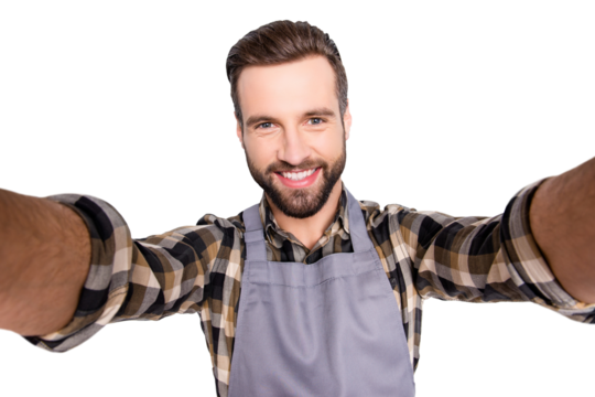 Self portrait of trendy stylish baker with hairstyle shooting selfie on smart phone with two hands, isolated on grey background, having video-call during break pause timeout