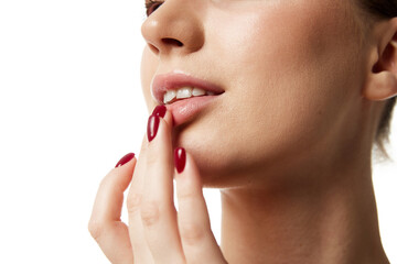 Naklejka premium Close up beautiful woman with bare shoulders applying lipbalm on lips against white studio background. Lipcare. Concept of natural beauty people, injections, wellness, spa procedures, cosmetology. Ad