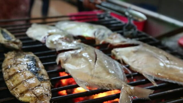Close up of the process of grilling grilled fish, selective focus shot.