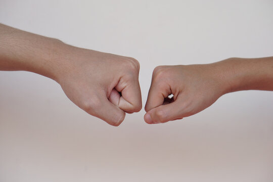 Close up  two hands bump their fists together for greeting. Concept, Body language. Hands gesture symbol for greeting, giving respect or approval as companionship between two people.                  