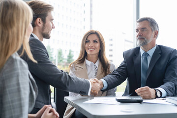 Fototapeta premium Handshake in agreement against young business people in board room meeting.