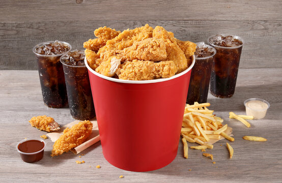 breaded fried chicken bucket with drink and french fries combo  wood background
