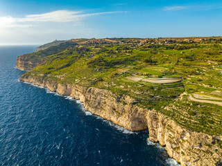 Fototapeta na wymiar Aerial drone view of green fields, cliffs and hills of Malta island, nature landscape, blue sky. Mediterranean sea