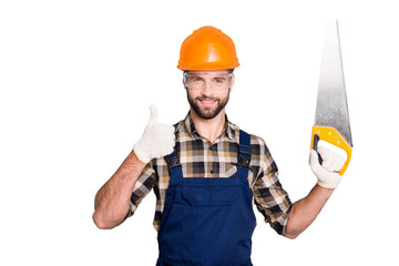 Portrait of handsome joyful master in hard hat, uniform, overall, shirt with stubble, showing thumb...