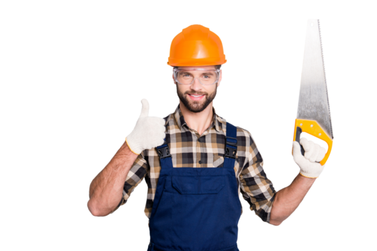 Portrait of handsome joyful master in hard hat, uniform, overall, shirt with stubble, showing thumb up, like sign holding having saw in arm, isolated on grey background
