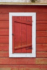 Red door on a old red painted wooden building.