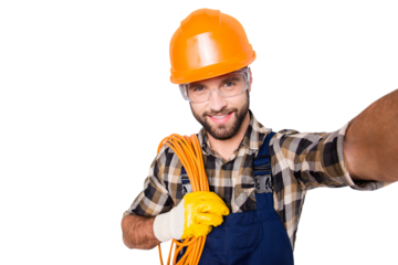 Self portrait of attractive joyful man in hardhat, overall, shirt, holding rolled cable on shoulder, blogger shooting selfie on front camera, isolated on grey background, having leisure
