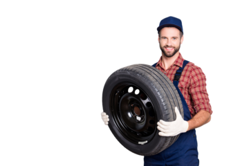 Portrait with copy space, empty place for advertisement of joyful cheerful mechanic in blue overall, shirt having, holding tire in arms, looking at camera, isolated on grey background