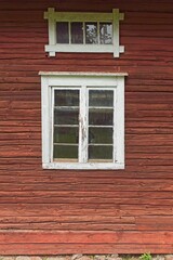 White framed windows on red wooden building.