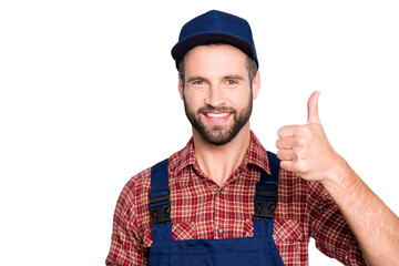 Close up portrait of handsome confident mechanic with stubble in shirt, overall, showing thumbup...