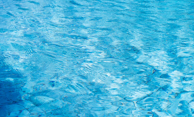 Swimming pool water sun reflection, blue ripped water background