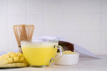 Yellow matcha drink. Mango matcha extract tea or latte, fruity healthy beverage on white background copy space